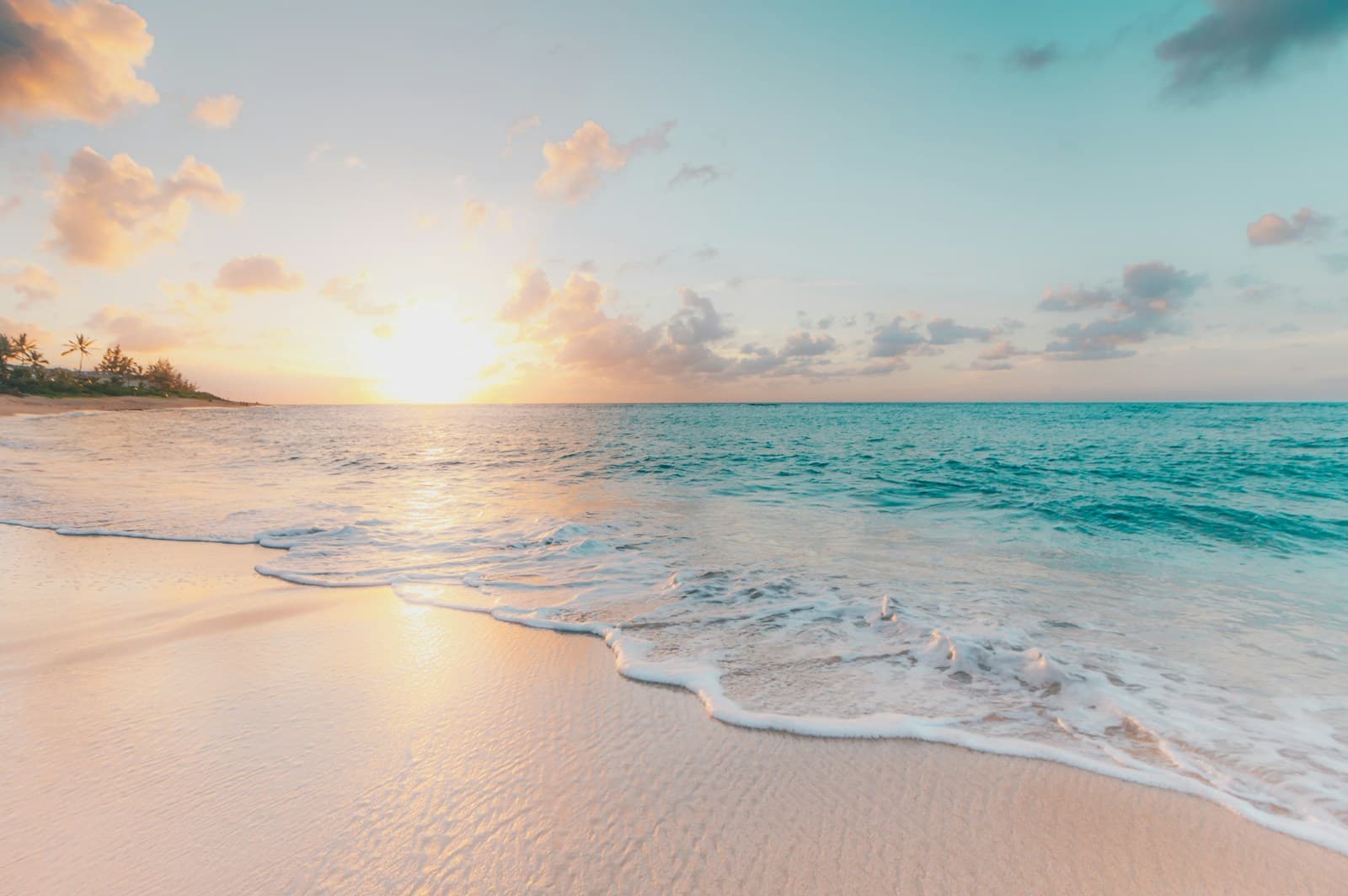 Turquoise water meeting a quiet sandy beach